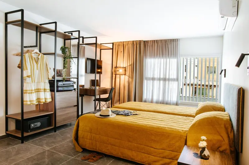 Une chambre lumineuse avec un lit double et un espace bureau.