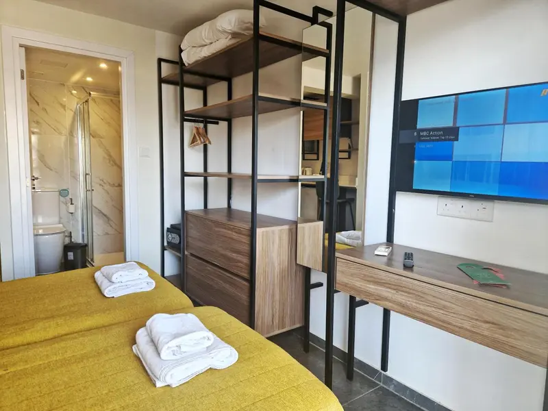 Une chambre jaune avec un lit superposé et un bureau.