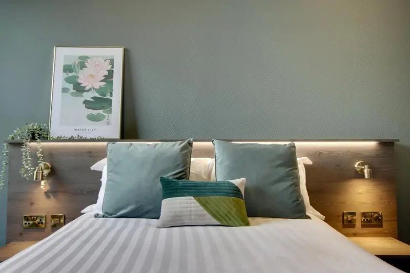 Un lit confortable est dispose dans une chambre aux murs verts.