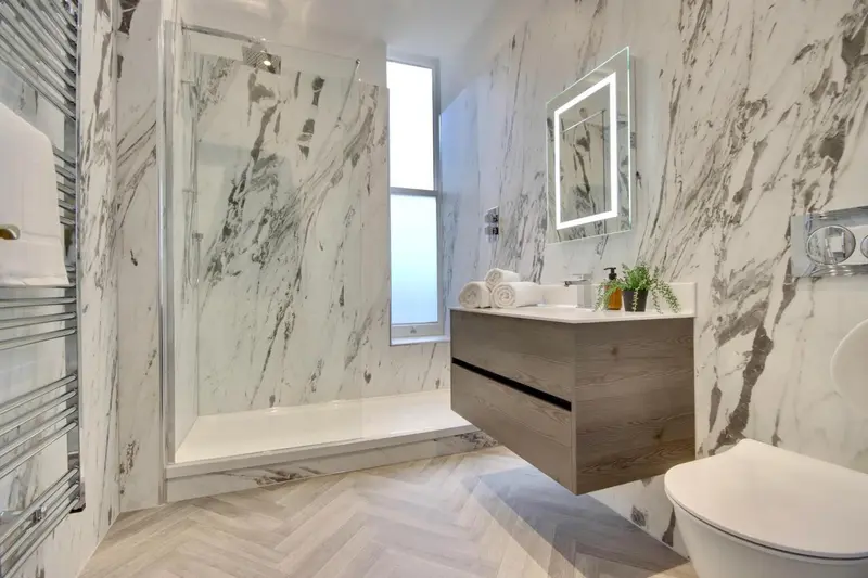 Une salle de bain moderne avec une douche à l'italienne et un meuble vasque suspendu.