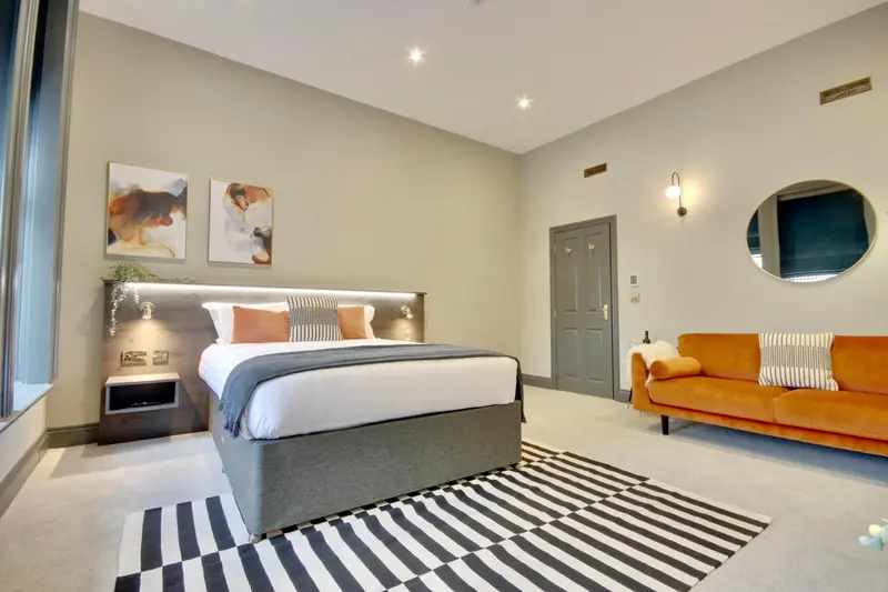 Une chambre moderne avec un grand lit et un canapé.
