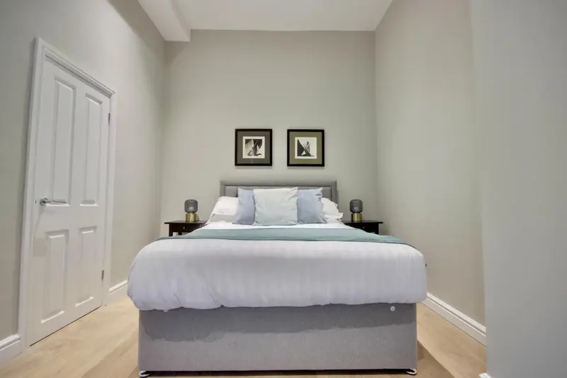 Une chambre avec un lit double et deux tables de chevet.