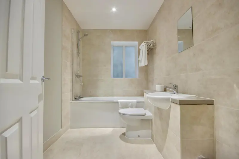 Une salle de bain claire avec baignoire et douche.