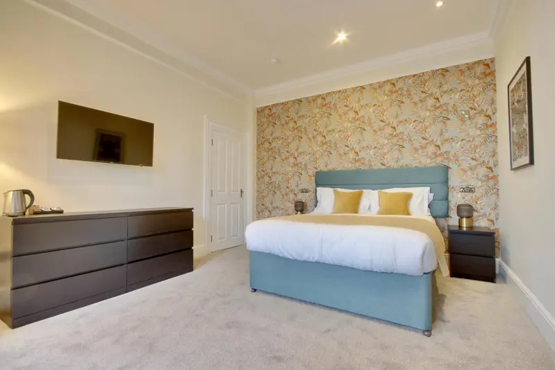 Une chambre à coucher lumineuse avec un grand lit et une commode.