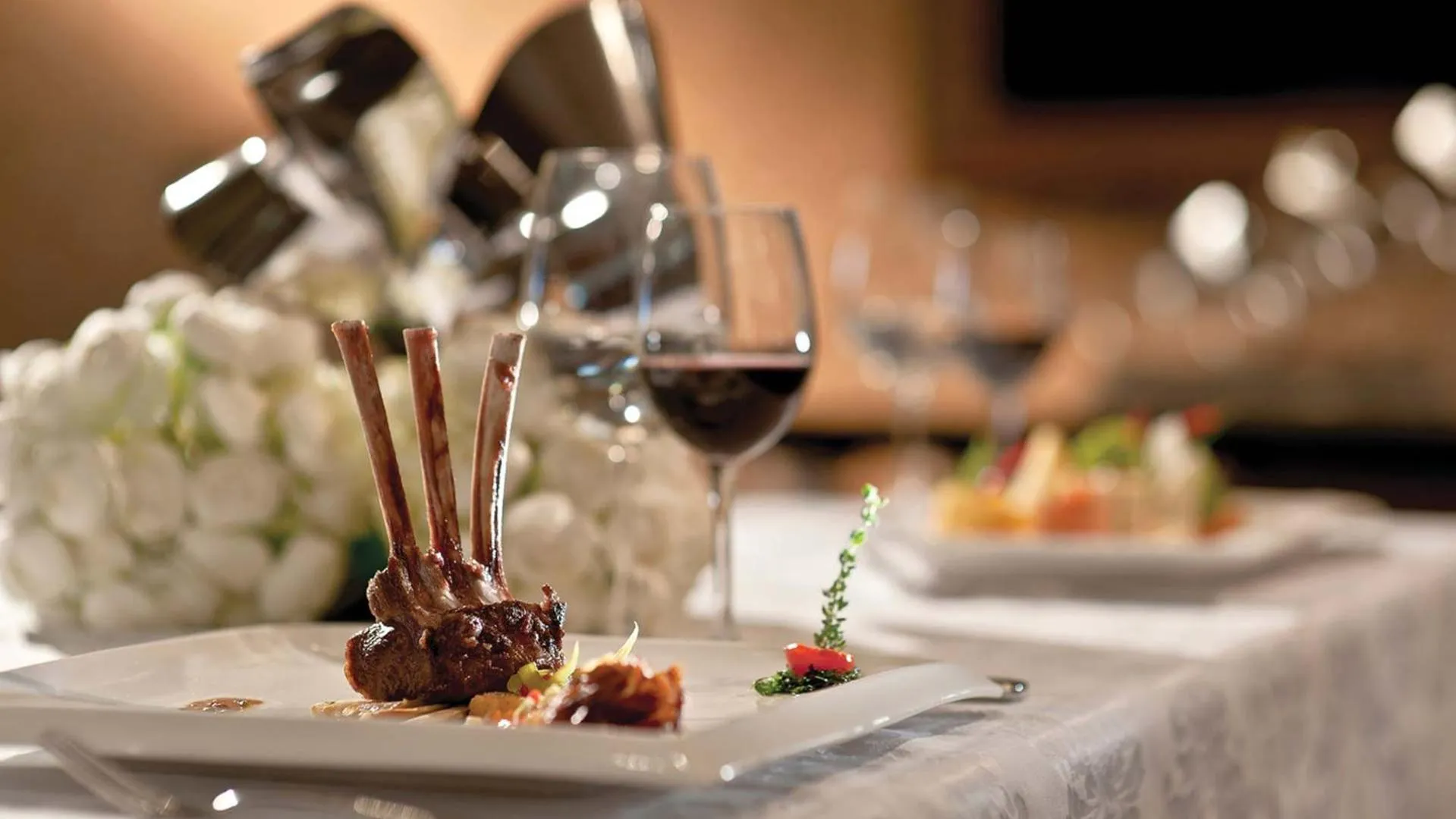 Assiettes de viande et de légumes présentées sur une table nappée.