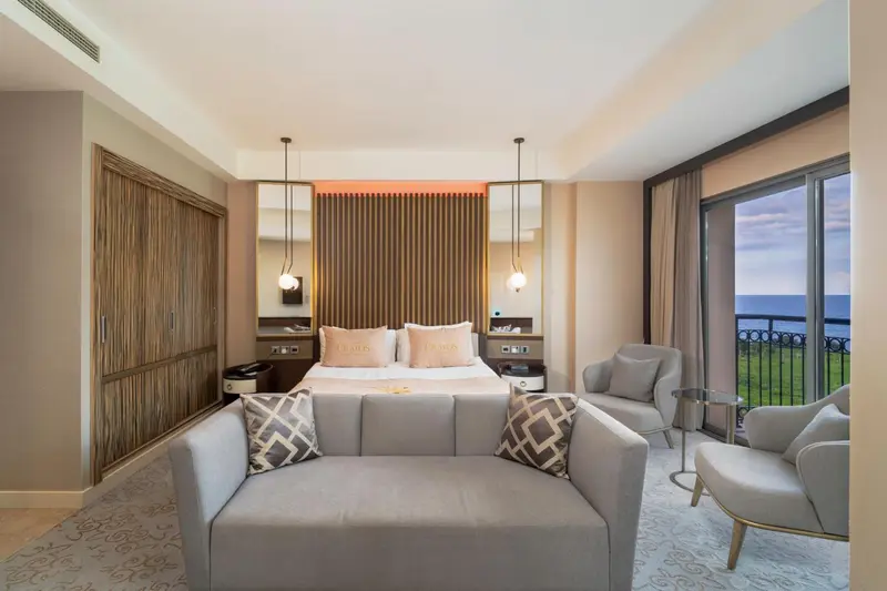 Une chambre lumineuse avec un grand lit et un coin salon.
