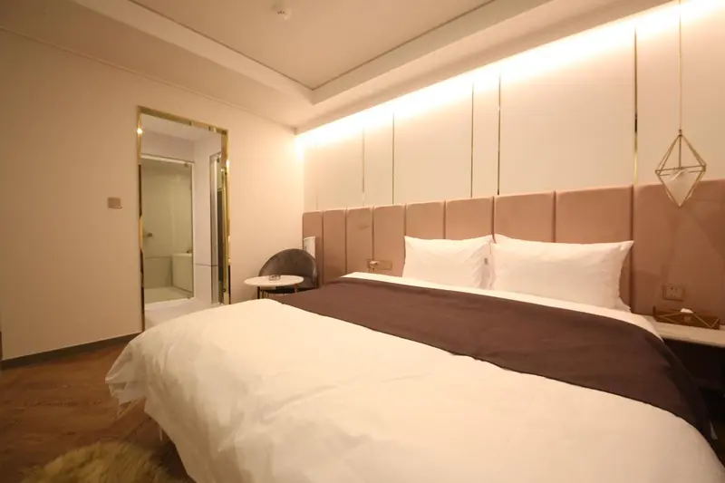 Une chambre lumineuse avec un grand lit et une décoration moderne.