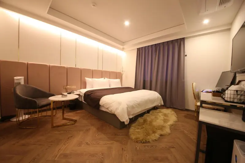 Une chambre lumineuse avec un grand lit et un coin salon.