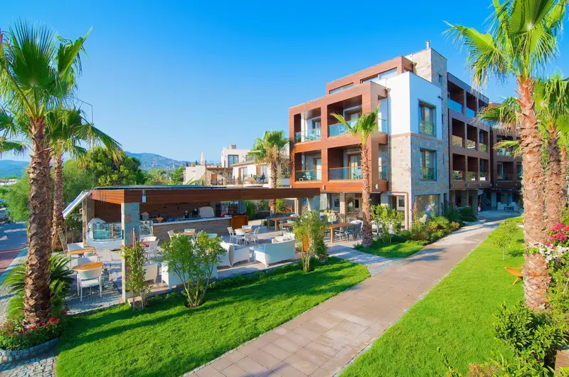 Bâtiment moderne avec terrasse et mobilier de jardin au premier plan.