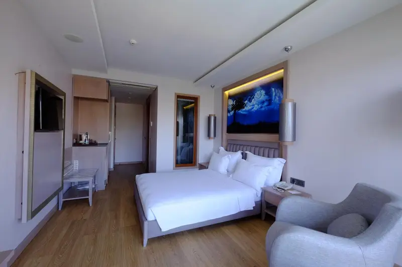 Chambre lumineuse avec un grand lit et un espace détente.