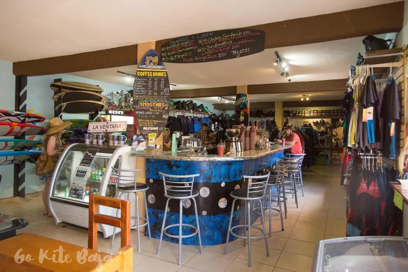Un comptoir de bar coloré avec des tabourets et une vitrine réfrigérée.