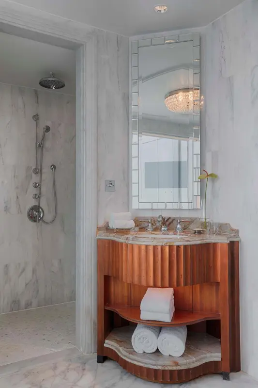 Une salle de bain lumineuse avec une douche à l'italienne et un meuble-lavabo en bois.