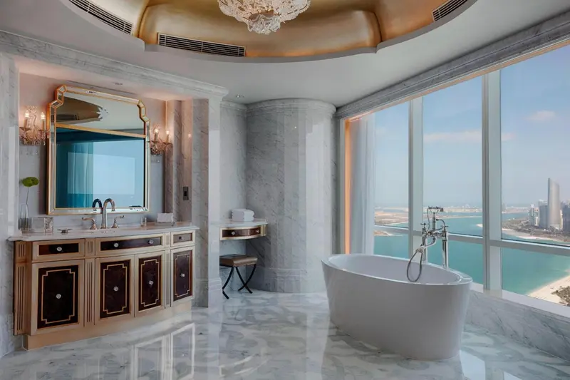 Une salle de bain luxueuse avec baignoire et vue sur la mer.