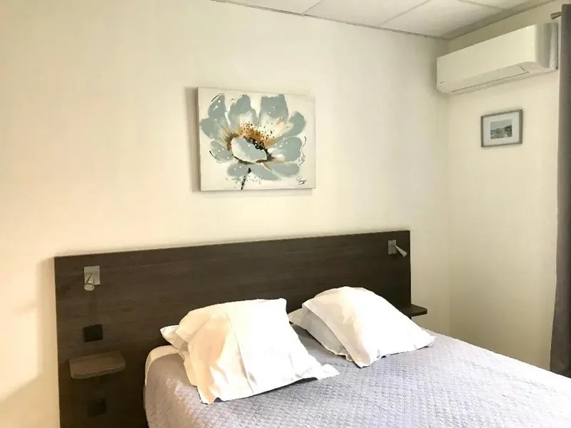 Une chambre avec un grand lit et une décoration florale au mur.