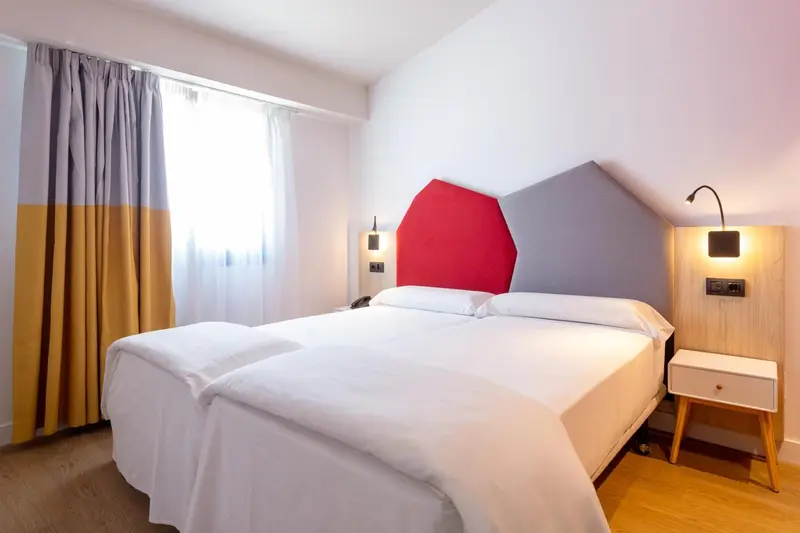 Une chambre lumineuse avec un grand lit et une décoration moderne.