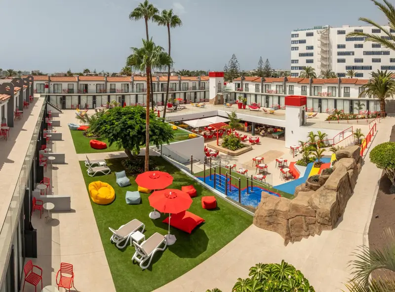 Vue aérienne d'un complexe hôtelier avec une cour intérieure verdoyante et une piscine.