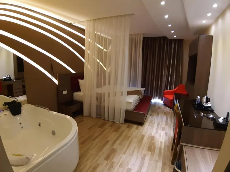 Une chambre spacieuse avec un jacuzzi et un coin salon.