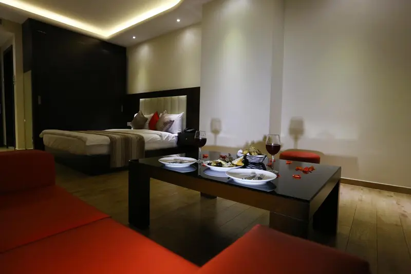 Une chambre avec un lit et une table basse décorée de plats et de boissons.
