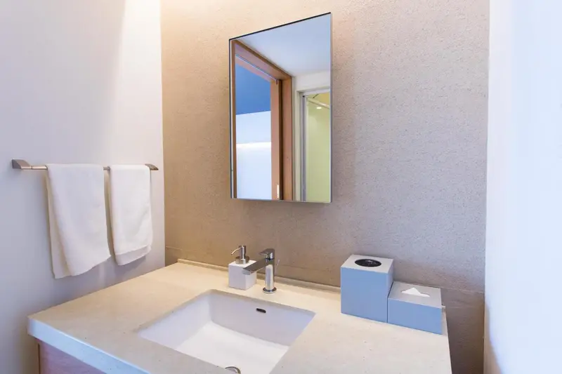 Une salle de bain avec un lavabo, un miroir et des serviettes.
