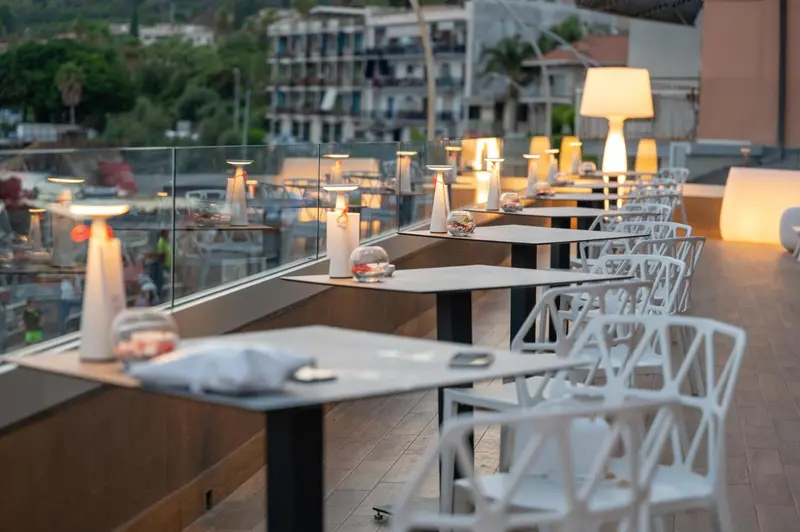 Terrasse aménagée avec tables et éclairages décoratifs.