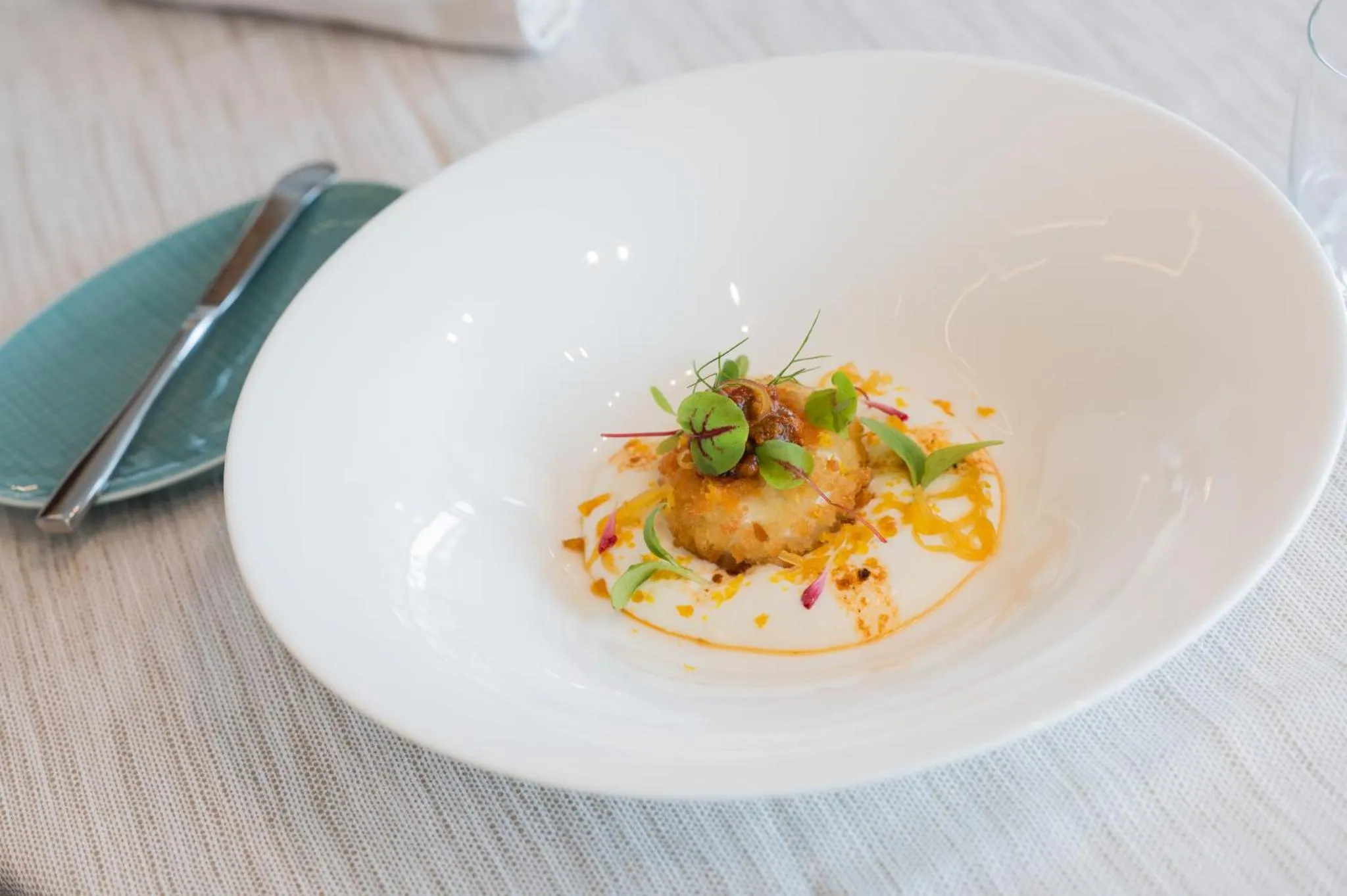 Assiette blanche ornée d'une préparation culinaire raffinée.
