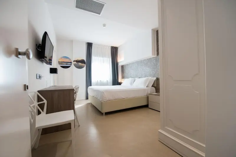 Une chambre lumineuse avec un lit double et un espace bureau.
