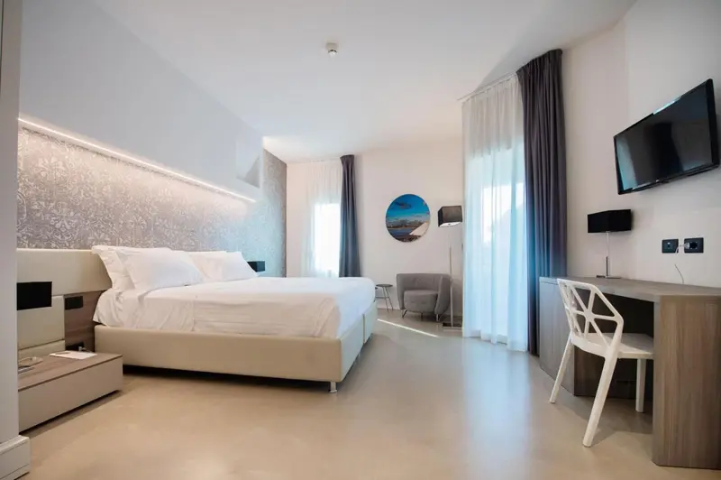 Une chambre lumineuse avec un grand lit et un espace bureau.