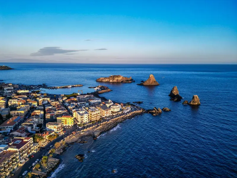 Vue aérienne d'une côte rocheuse avec des bâtiments et des îlots en mer.