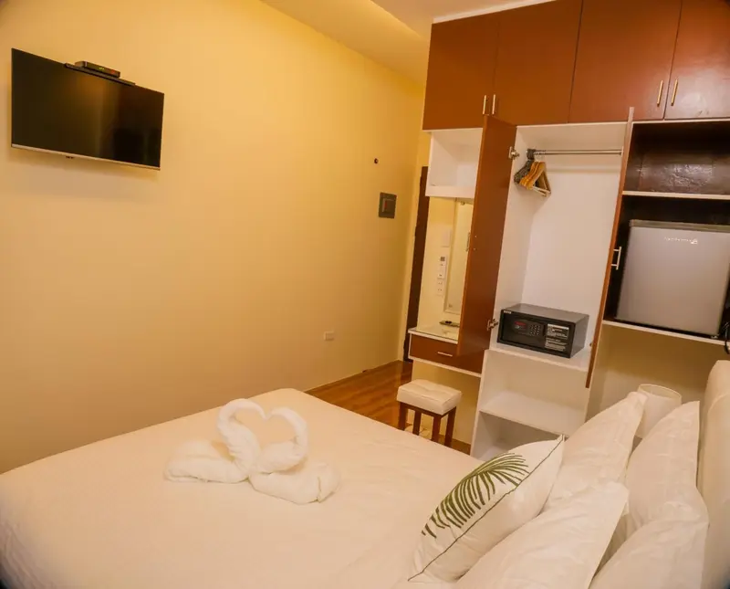 Une chambre lumineuse avec un lit décoré de serviettes en forme de cœur.