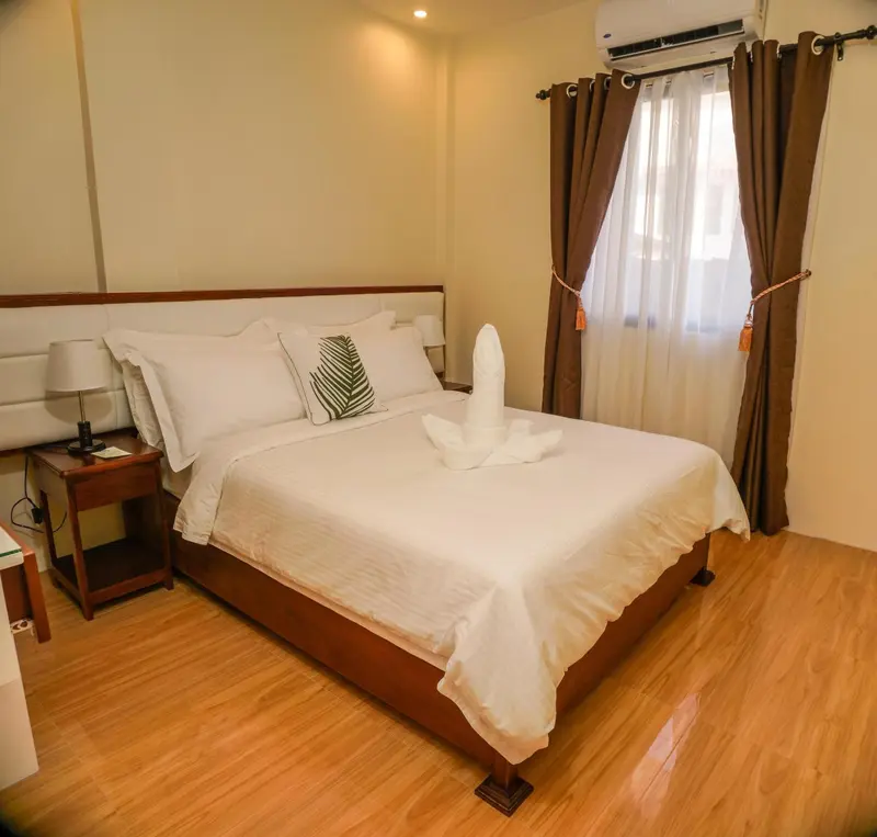 Une chambre lumineuse avec un grand lit recouvert de draps blancs.