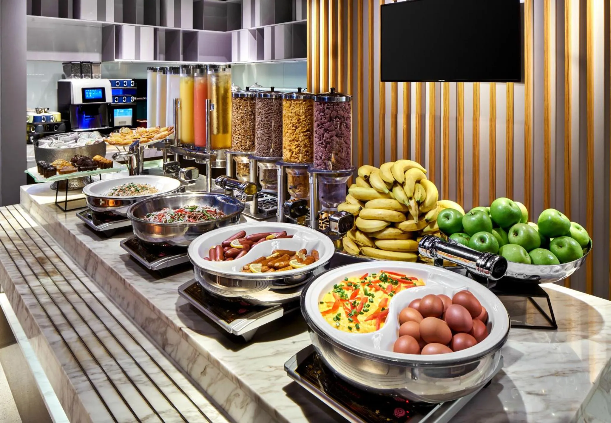 Un buffet propose une variété de plats, de fruits et de céréales.