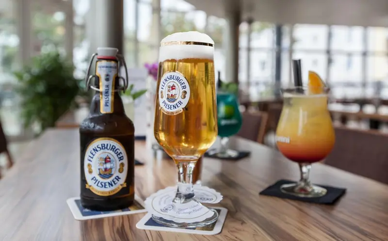 Une table en bois présente des boissons rafraîchissantes et colorées.