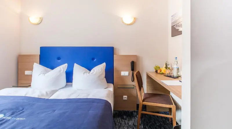 Une chambre d'hôtel avec un lit double et une table de chevet.