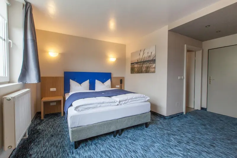 Une chambre d'hotel avec un lit double et un radiateur.