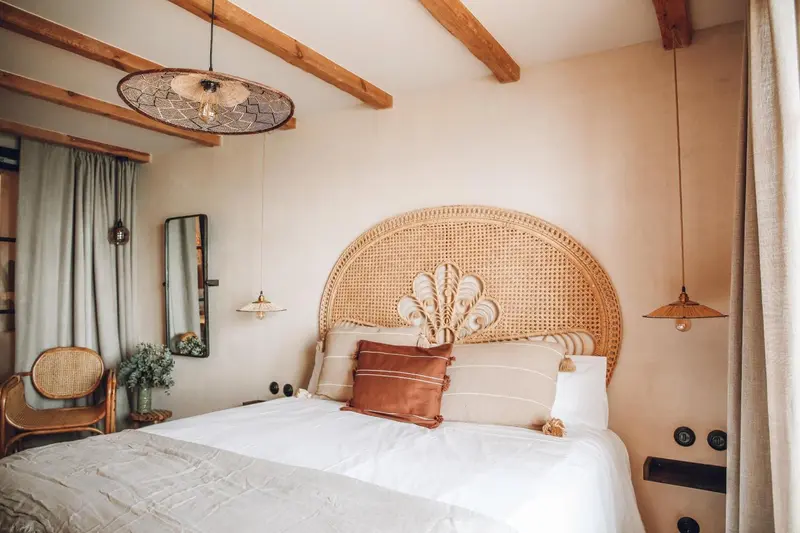 Une chambre à coucher avec un grand lit et une tête de lit en rotin.
