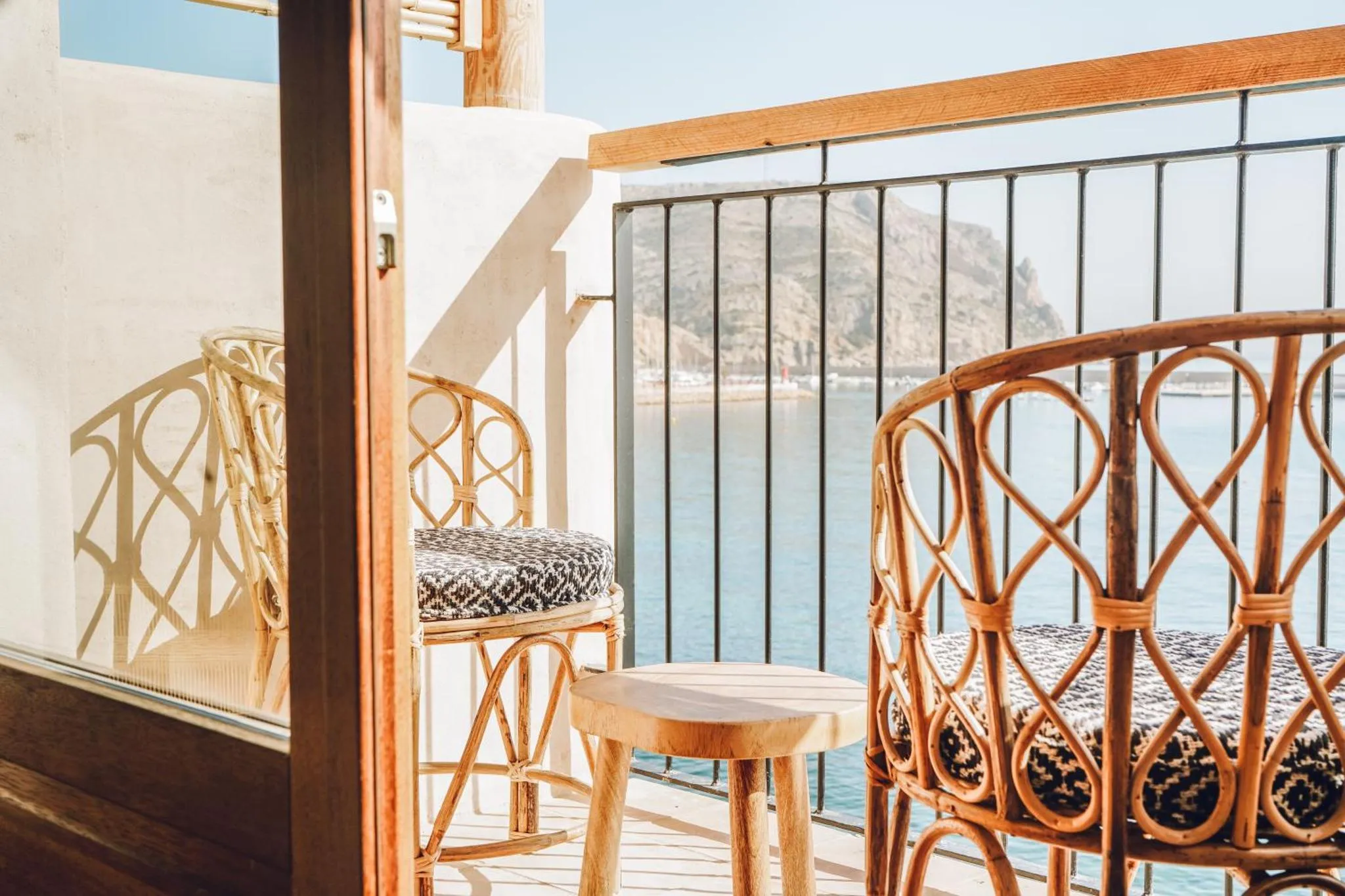 Terrasse avec mobilier en rotin donnant sur la mer.