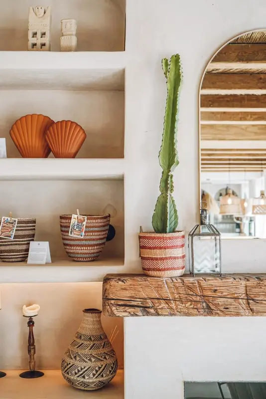 Une étagère décorative expose des objets artisanaux et des plantes.