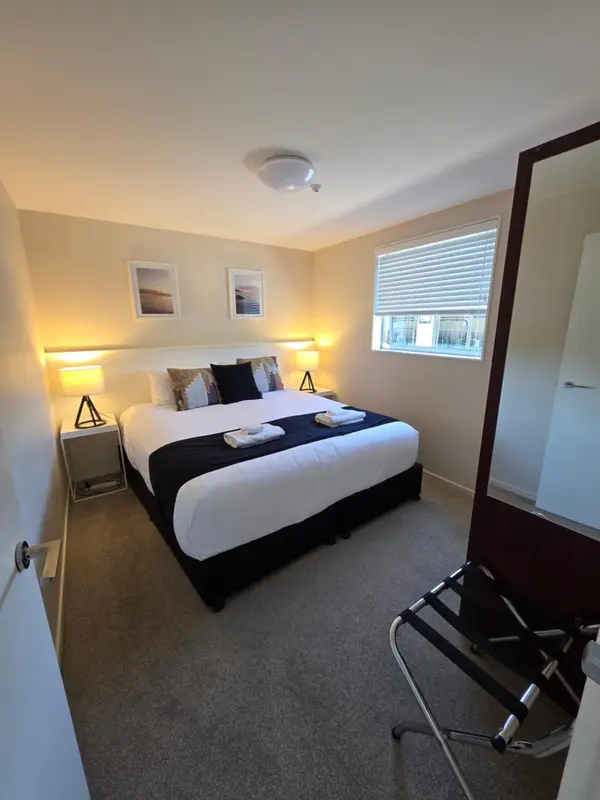 Une chambre avec un grand lit recouvert d'une courtepointe noire et blanche.
