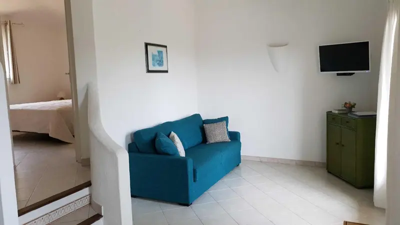 Un canapé bleu turquoise dans un espace de séjour lumineux.