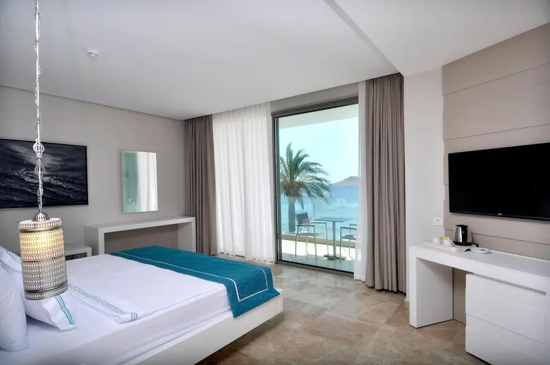 Une chambre lumineuse avec un grand lit et une vue sur la mer.