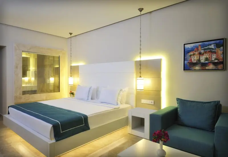 Une chambre lumineuse avec un grand lit et un coin salon.