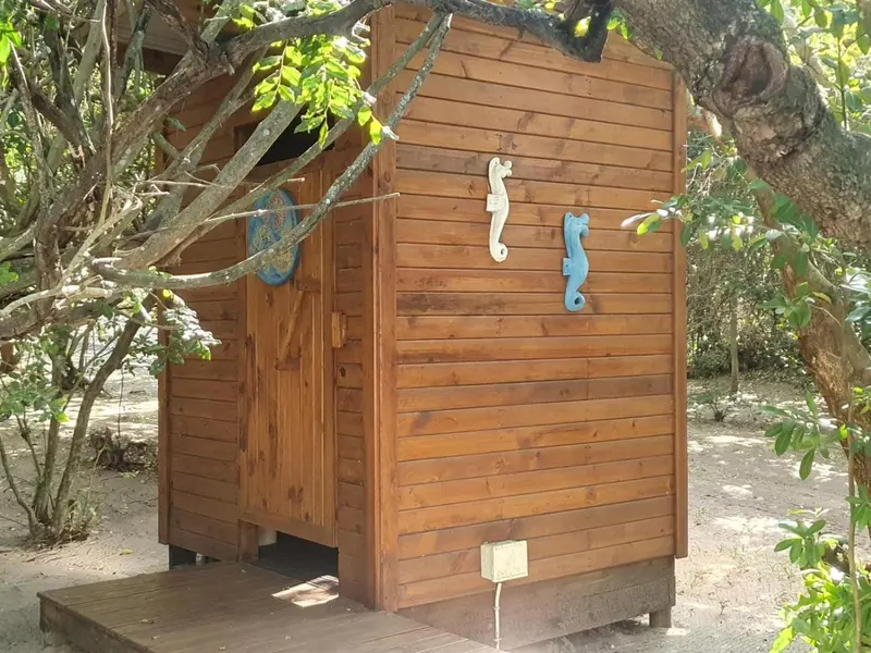 Petite cabane en bois avec des décorations marines suspendues à la façade.