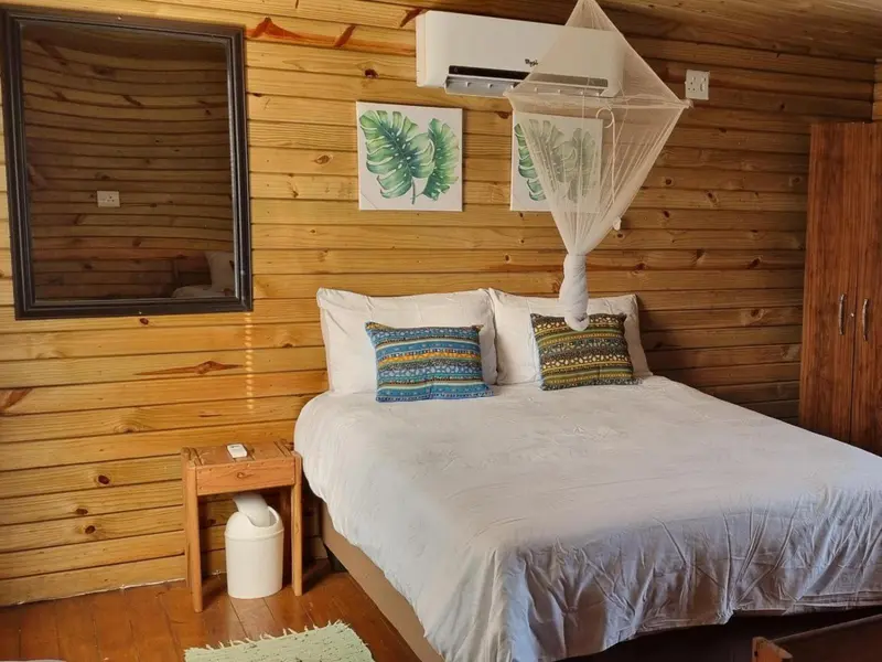 Une chambre lumineuse avec un lit recouvert d'une moustiquaire et décorée de coussins.