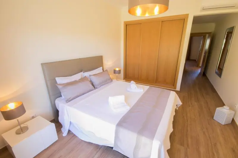 Une chambre lumineuse avec un grand lit et une décoration sobre.