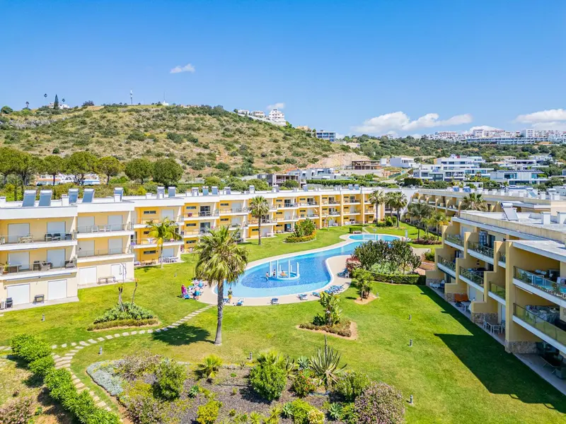 Vue aérienne d'un complexe hôtelier avec piscine et végétation luxuriante.