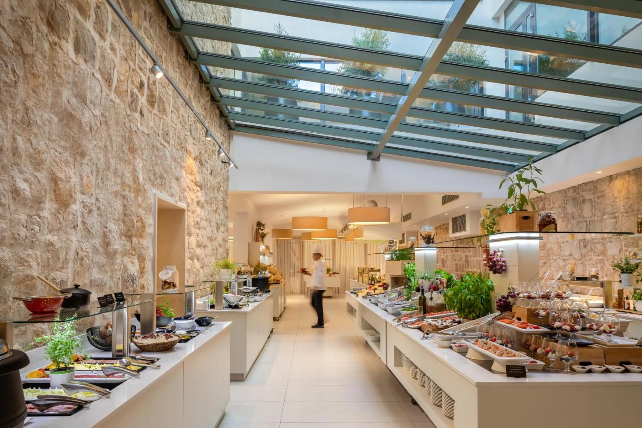 Un buffet de nourriture est présenté dans une salle lumineuse avec un plafond vitré.