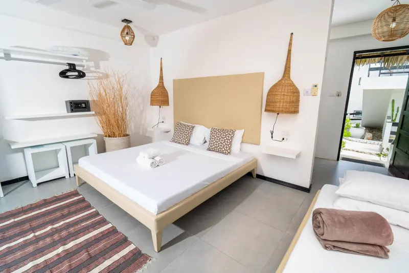 Une chambre lumineuse avec un grand lit et une décoration naturelle.