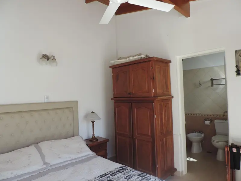 Une chambre lumineuse avec un lit et un accès à une salle de bain.