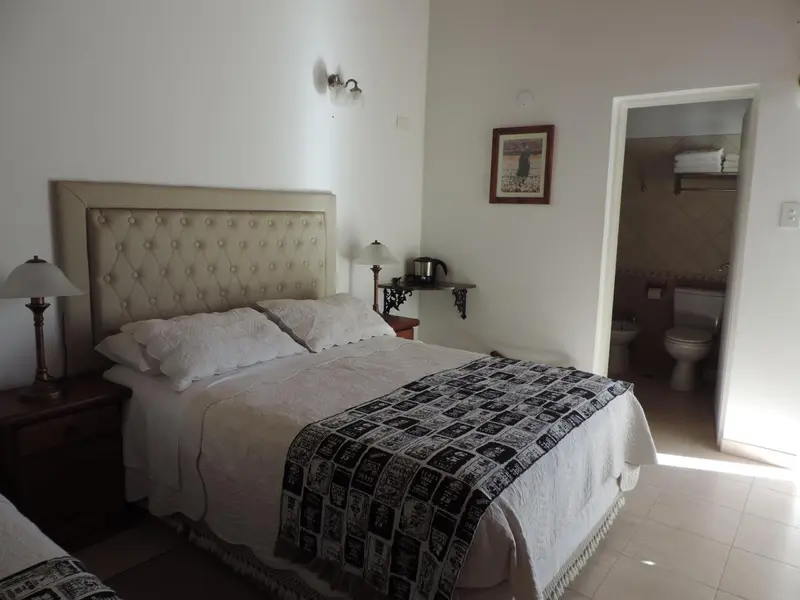 Une chambre lumineuse avec un grand lit recouvert d'une couverture.