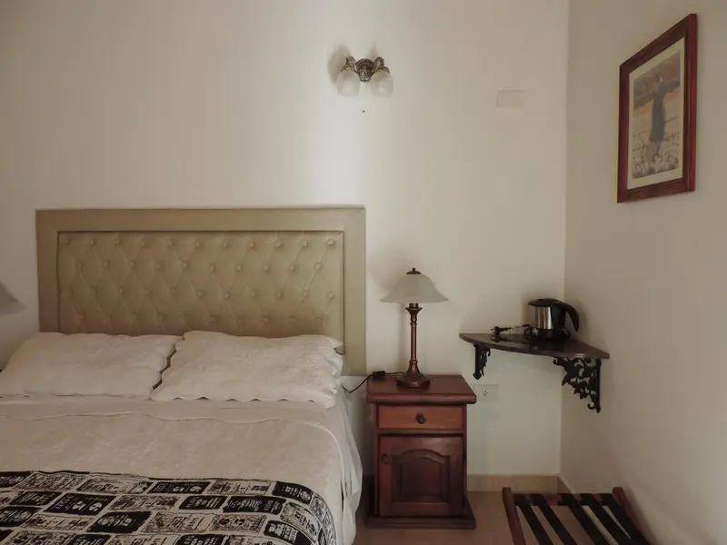 Une chambre lumineuse avec un grand lit et une table de chevet en bois.